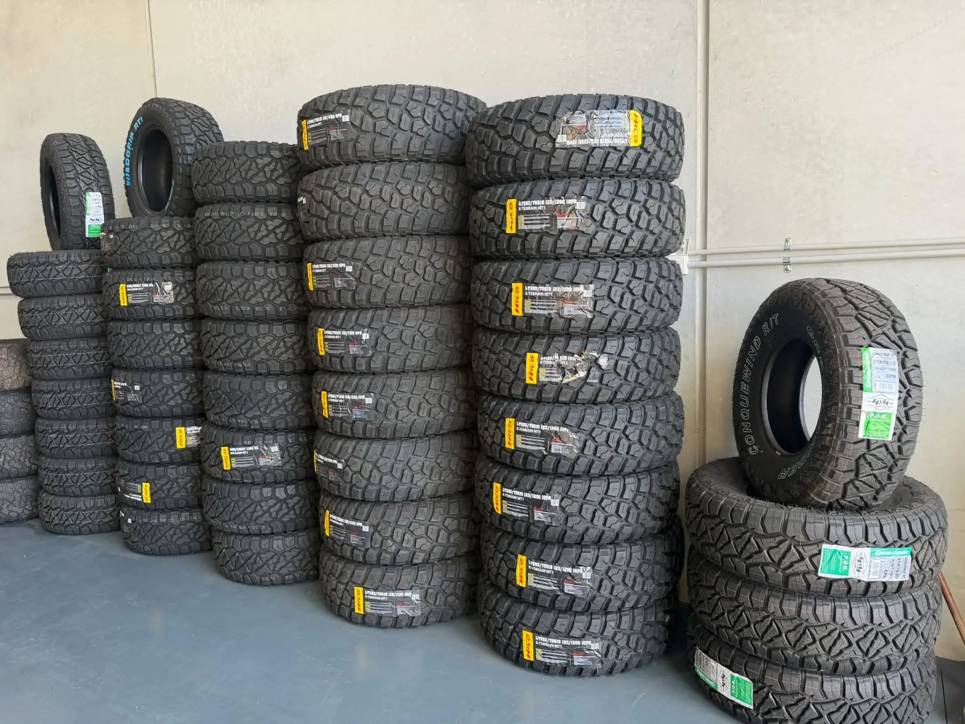 Stacks of Hilo and Grenlander four wheel drive tyres in stock along the wall of the Kelso workshop at Australia's Most Wanted Wheels and Tyres Bathurst