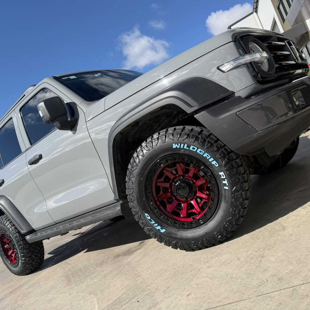 Grey dual cab ute lifted on red alloy wheels with Hilo Wildgrip all-terrain tyres outside the Kelso workshop at Australia's Most Wanted Wheels and Tyres Bathurst