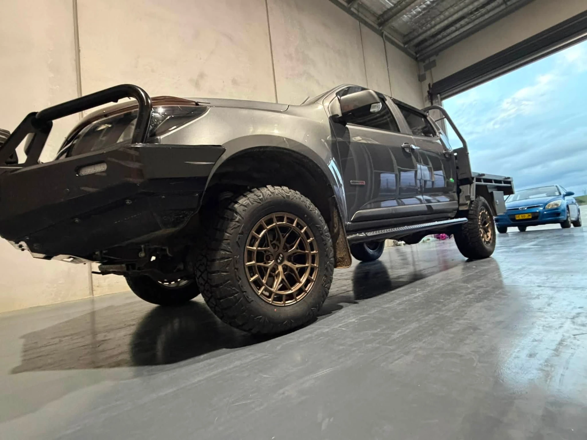 Grey dual cab tray ute on bronze alloy wheels and all-terrain tyres in the workshop bay at Australia's Most Wanted Wheels and Tyres Bathurst in Kelso
