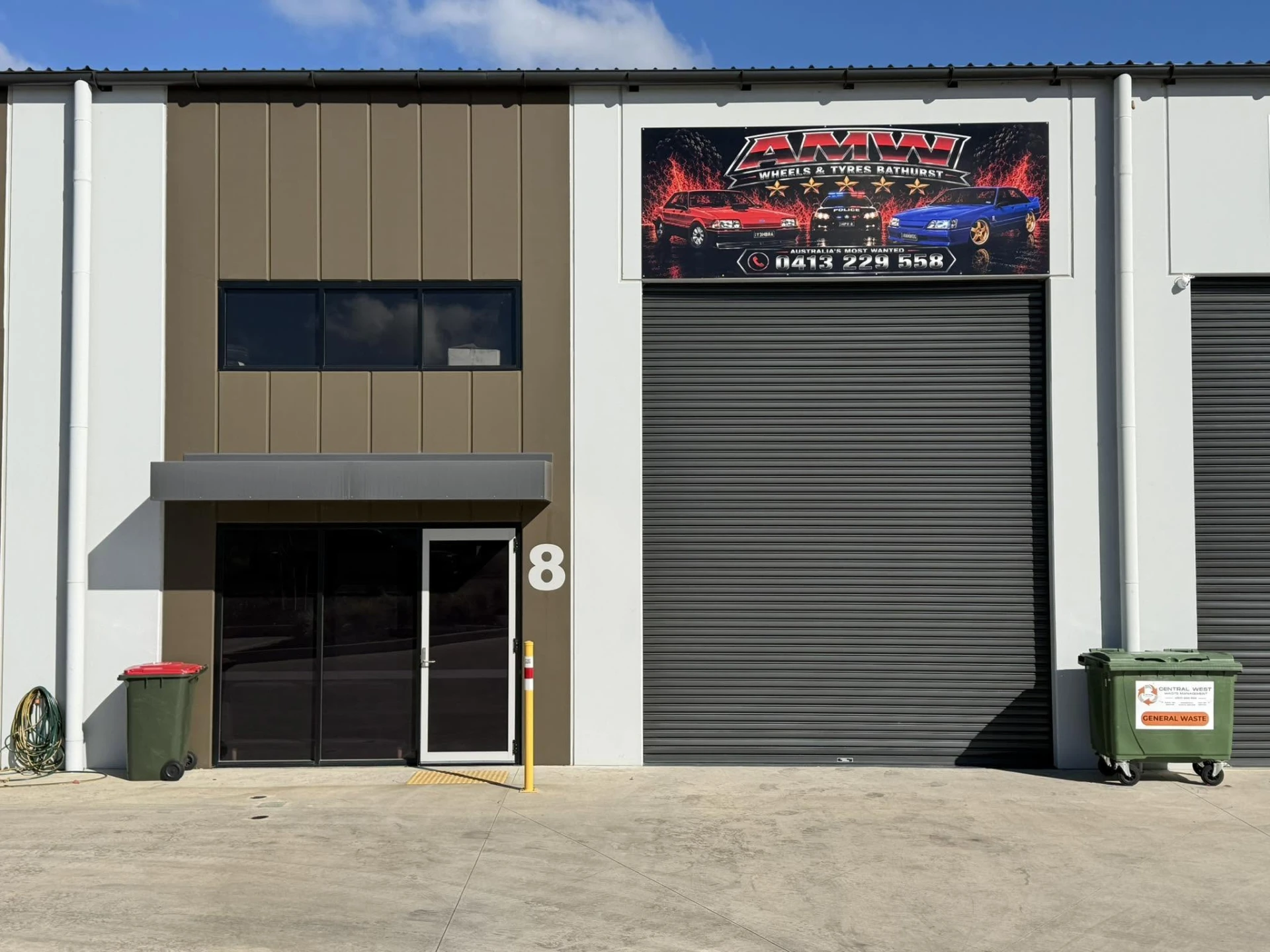 Signed roller door frontage of Australia's Most Wanted Wheels and Tyres Bathurst workshop at unit 8 in Kelso