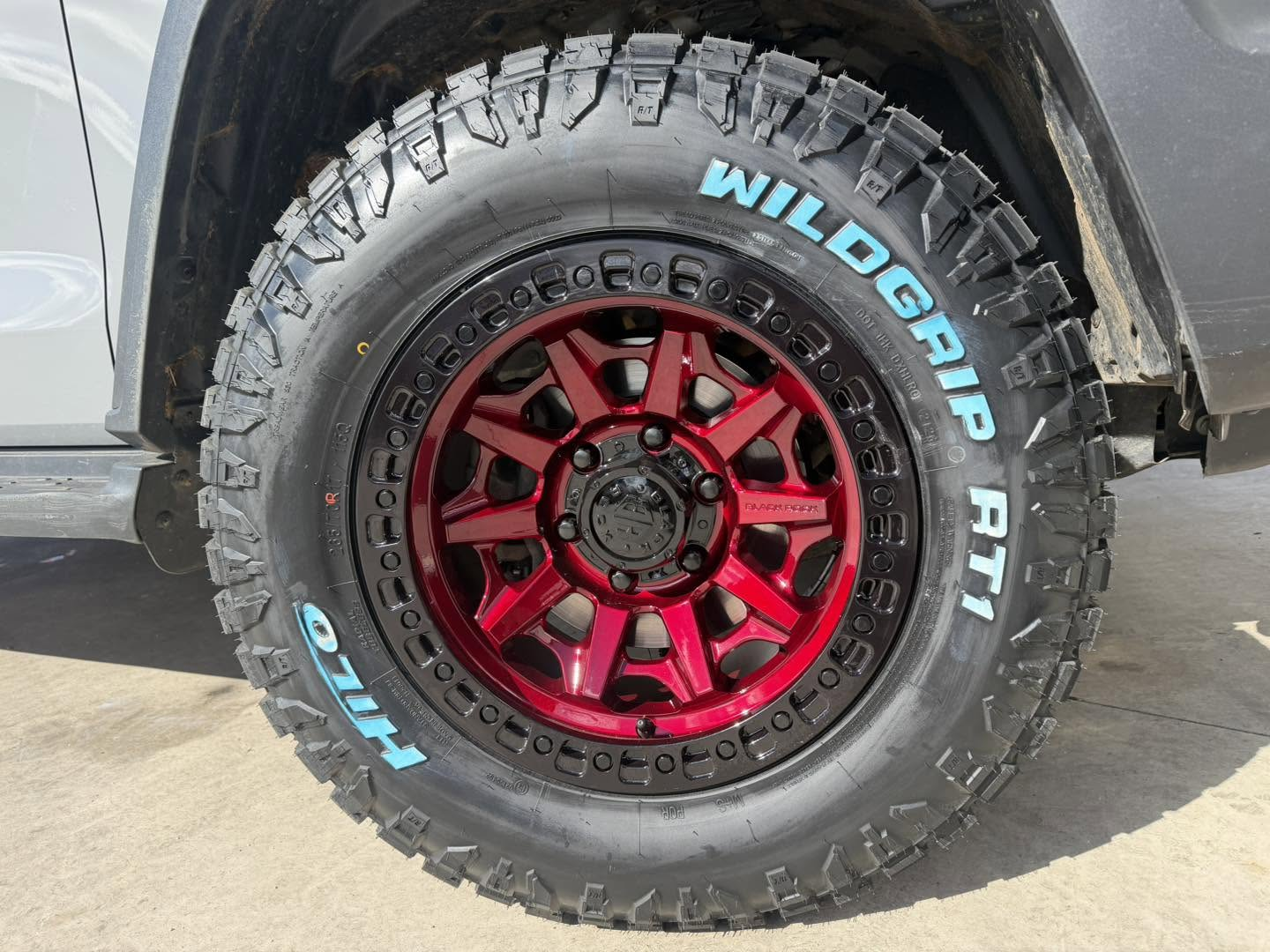 Close-up of a candy red Black Rock alloy wheel fitted with a Hilo Wildgrip RT1 all-terrain tyre on a 4WD at Australia's Most Wanted Wheels and Tyres Bathurst in Kelso